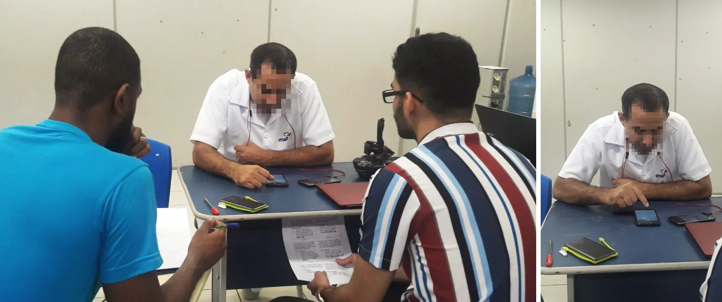 Two researchers interviewing a participant seated at a table.